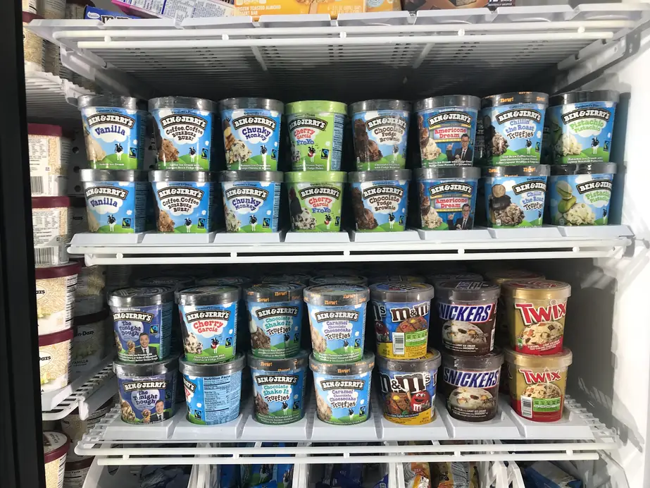 Glass freezer door of Ben & Jerry's and candy ice cream pints